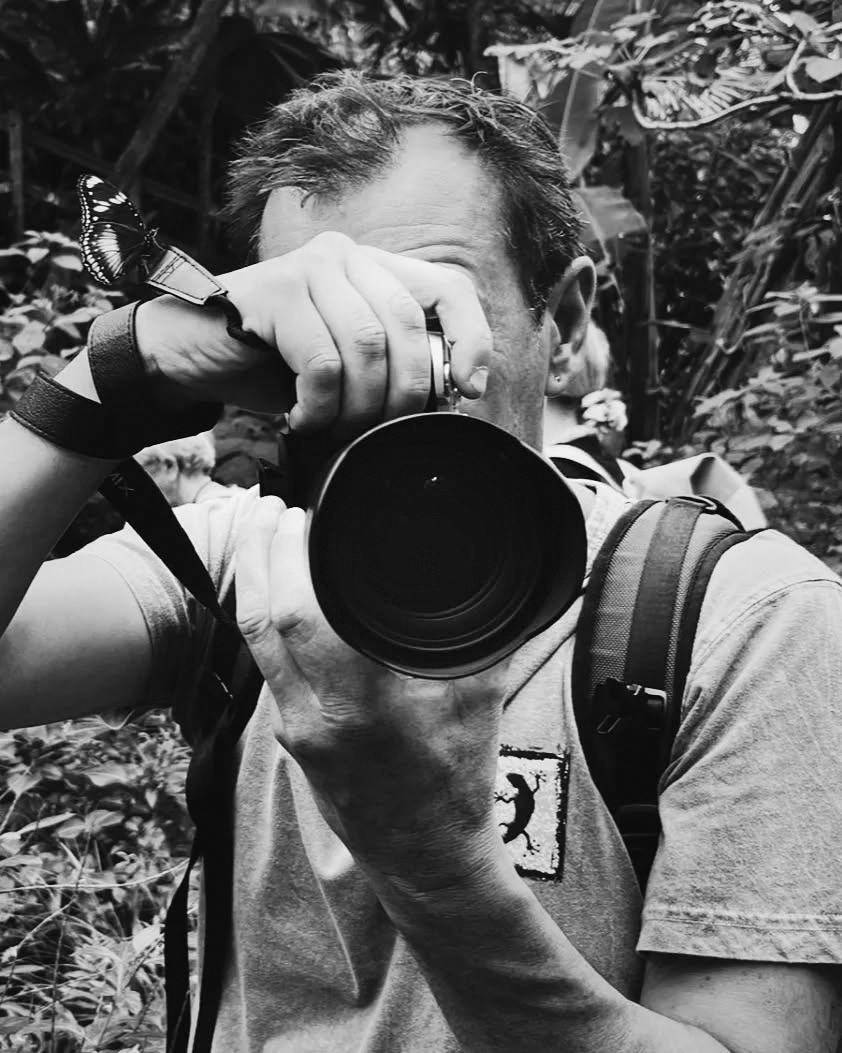 Michel Perrissin-Faber photographiant, un papillon posé sur sa montre